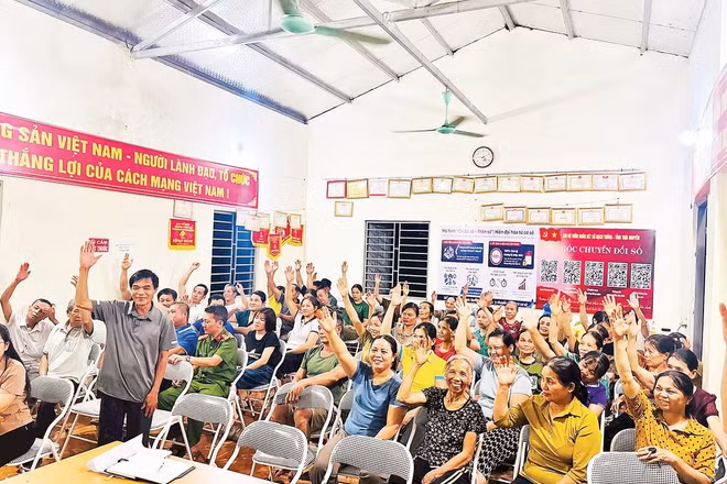 Đại diện các hộ gia đình thôn Đoàn Kết, xã Bạch Thông biểu quyết nhất trí phương án sắp xếp, tổ chức lại thôn, bản (Ảnh MINH NGUYỆT)