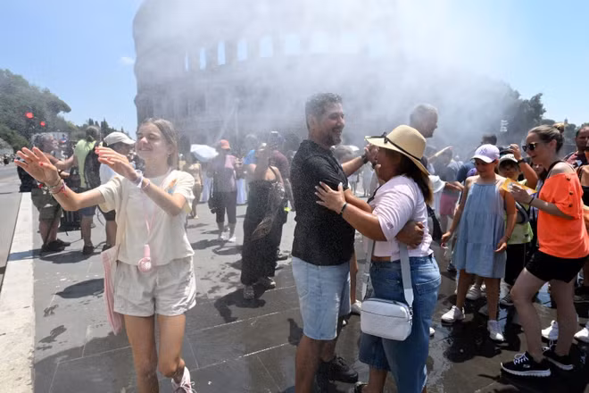 Người dân làm mát gần thiết bị phun sương tại Rome, Italy ngày 26/6/2026. (Ảnh: THX/TTXVN)