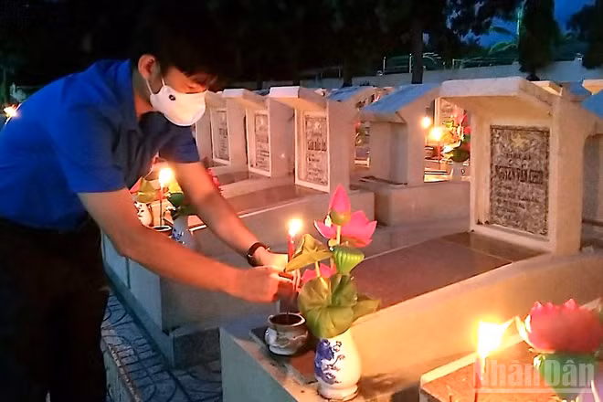 Đoàn viên Cà Mau thắp nến tri ân tại Nghĩa trang liệt sĩ tỉnh. (Ảnh HỮU TÙNG)