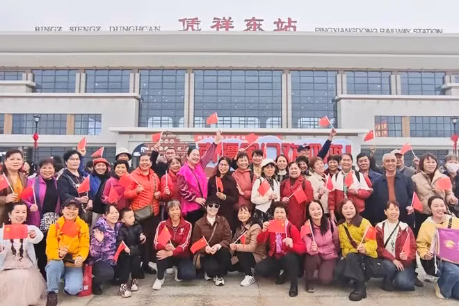 Hành khách chụp ảnh trước ga Bằng Tường Đông. (Ảnh: Nhân dân nhật báo)