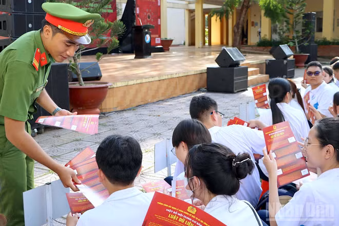 Cán bộ Công an tỉnh Cà Mau phát tờ rơi tuyên truyền nâng cao nhận thức pháp luật trên không gian mạng cho học sinh Trường trung học phổ thông chuyên Phan Ngọc Hiển.