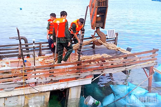 Cán bộ, chiến sĩ Đồn Biên phòng Hòn Chuối hỗ trợ trục vớt tàu cá gặp nạn trên vùng biển Cà Mau. 