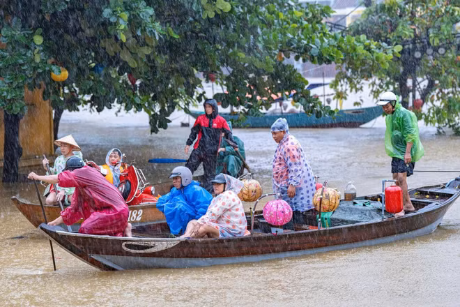 Các lực lượng chức năng căng mình ứng cứu người dân vùng ngập lụt ở Hội An. (Ảnh Tùng Lâm)