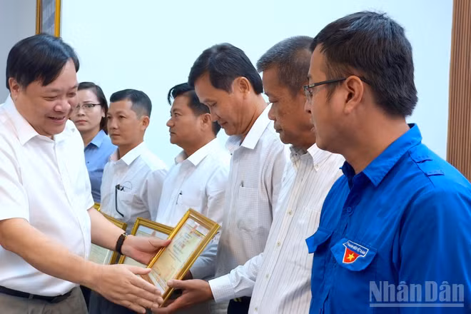 Chủ tịch Ủy ban nhân dân tỉnh Cà Mau Phạm Thành Ngại (bìa trái) tặng Bằng khen cho các cá nhân có nhiều đóng góp trong phong trào xóa nhà tạm, nhà dột nát.