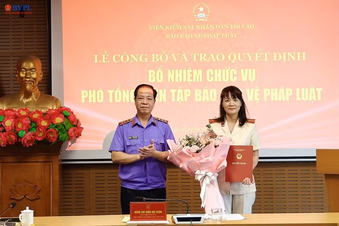  Đồng chí Trần Hải Quân, Phó Viện trưởng VKSND tối cao trao quyết định và tặng hoa chúc mừng đồng chí Hồ Thị Kim Thoan được bổ nhiệm giữ chức vụ Phó Tổng Biên tập Báo Bảo vệ pháp luật.