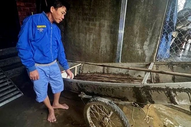 Ông Trần Công Thành bên chiếc ghe nhỏ dùng để cứu người trong lũ dữ.