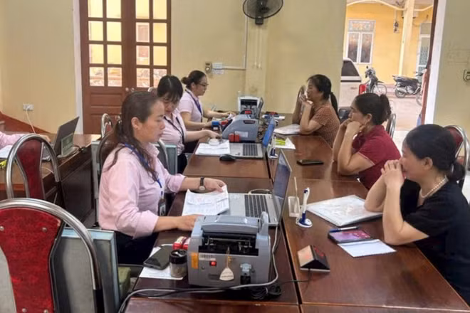 Người dân giao dịch tại điểm giao dịch của Ngân hàng Chính sách xã hội.