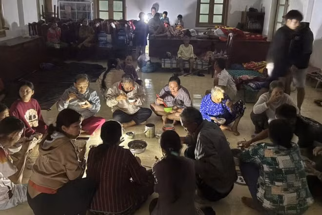 Người dân xã Xuân Cảnh quây quần dùng bữa tối tại Doanh trại Đồn Biên phòng Xuân Hòa trong thời gian trú tránh bão số 13.