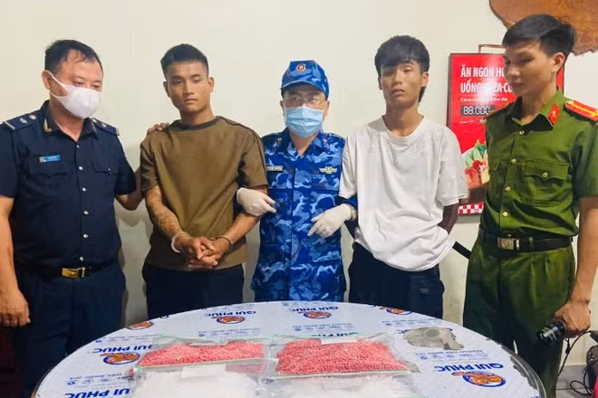 Hai đối tượng cùng tang vật trong vụ vận chuyển trái phép 18.000 viên hồng phiến và 2kg ma túy đá bị lực lượng chức năng bắt giữ.
