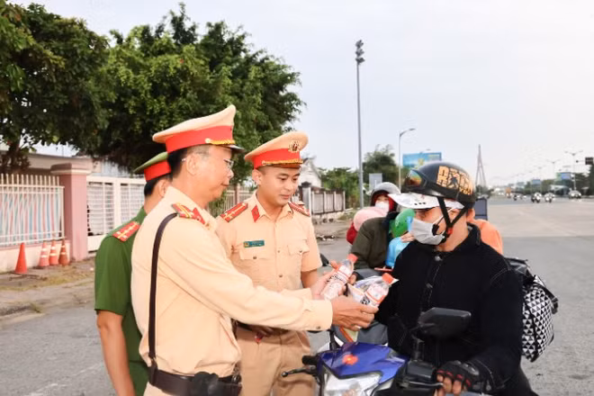 Công an Cần Thơ phát nước cho người dân trên đường về nhà đón Tết.