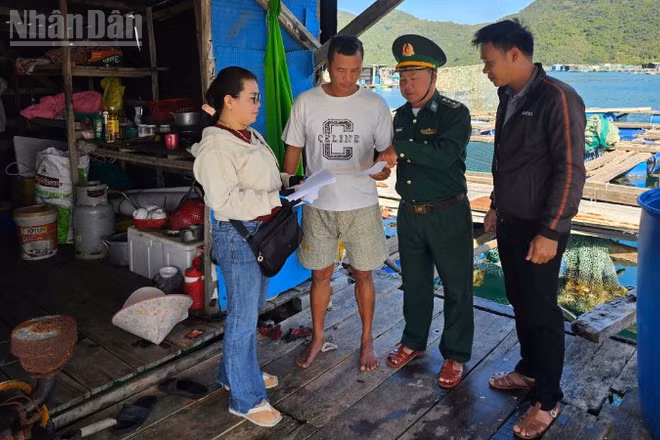 Cán bộ Đồn Biên phòng An Hải cùng các chủ phương tiện và ngư dân trao đổi, hướng dẫn kê khai, rà soát hồ sơ tàu cá tại lồng bè. (Ảnh: THÙY DUNG)