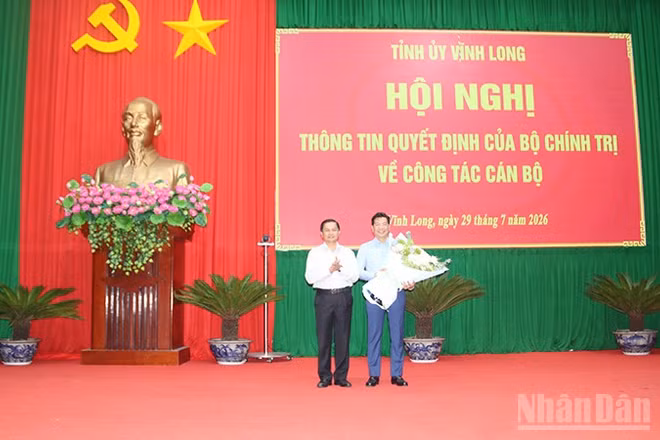 Đồng chí Nguyễn Mạnh Hùng nhận hoa chúc mừng của đồng chí Trần Văn Lâu, Ủy viên Trung ương Đảng, Bí thư Tỉnh ủy Vĩnh Long.