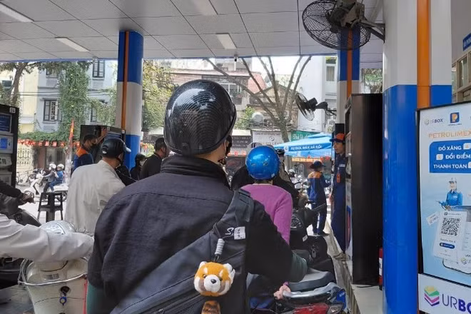 Người dân xếp hàng mua xăng tại cửa hàng trên phố Trần Hưng Đạo (Hà Nội). 