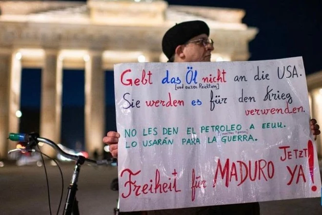 Một người đàn ông tham gia cuộc biểu tình phản đối hành động tấn công Venezuela của Mỹ tại Cổng Brandenburg ở Berlin, Đức, ngày 5/1/2026. (Ảnh: Tân Hoa xã)