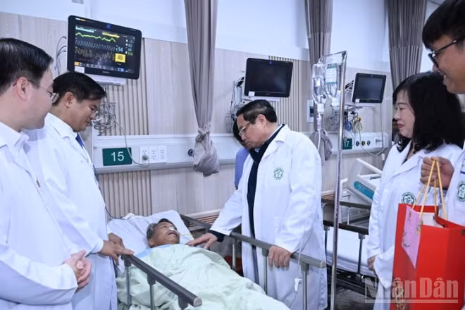 Thủ tướng Phạm Minh Chính thăm, tặng quà chúc Tết một bệnh nhân đang điều trị tại Trung tâm cấp cứu A9, Bệnh viện Bạch Mai. (Ảnh: Trần Hải)