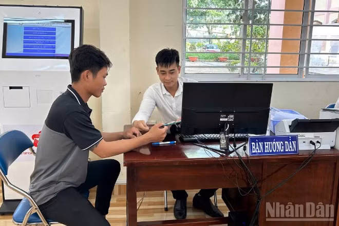 Cán bộ Trung tâm Phục vụ hành chính công xã Mỹ Lợi hướng dẫn người dân thao tác nộp hồ sơ trực tuyến. 