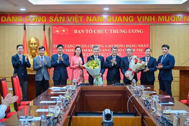 Tập thể lãnh đạo Ban Tổ chức Trung ương tặng hoa các đồng chí Hoàng Đăng Quang và Nguyễn Quang Dương. (Ảnh: BẢO LONG)