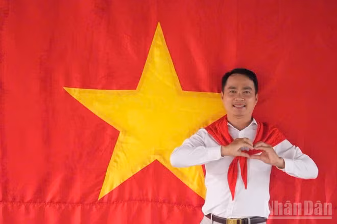 Tiến sĩ Võ Văn Sơn, giảng viên trẻ của Trường đại học Tiền Giang chụp ảnh cùng cờ Tổ quốc.