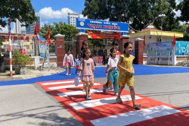Học sinh Trường tiểu học Vạn Phúc (Hà Nội) tự tin đi trên đoạn đường dành riêng cho người đi bộ khu vực trước cổng trường.