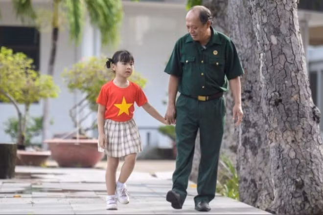 Thượng sĩ Nguyễn Chí Tường cùng con một nhân viên Vinamilk tại Trung tâm Điều dưỡng Thương binh và Người có công Long Đất. (Ảnh: THANH BÌNH)