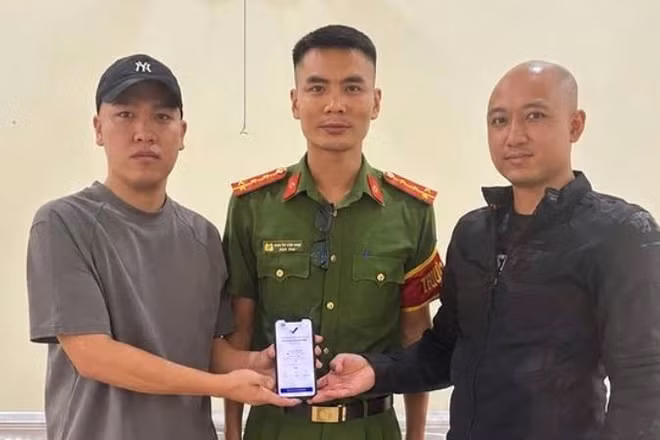 Anh Hoàng Quốc Cường (bên trái) trả lại 5 tỷ đồng chuyển khoản nhầm cho anh Quân trước sự chứng kiến của đại diện Công an xã Hoàn Lão. (Ảnh: Công an xã Hoàn Lão)