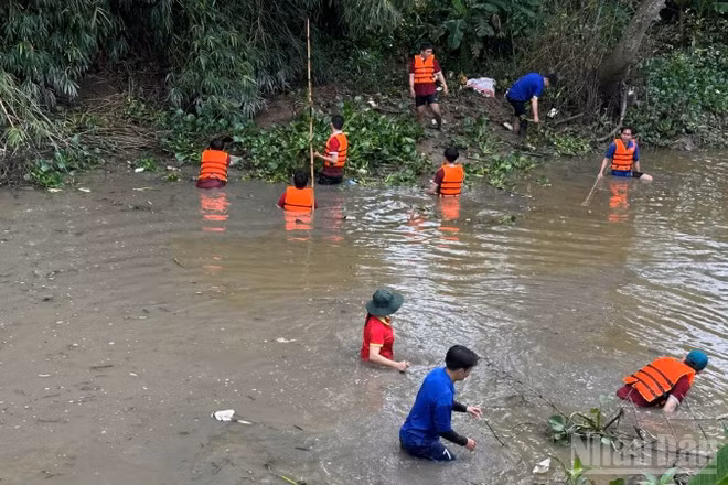 Đoàn viên, thanh niên xã Lấp Vò, tỉnh Đồng Tháp dọn rác dưới kênh. 