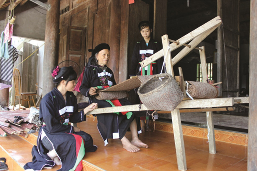 Nghệ nhân Trạc Thị Ngọn (ngồi giữa) hướng dẫn các phụ nữ Sán Chay cách dệt thổ cẩm. (Ảnh: Báo Dân tộc và phát triển)