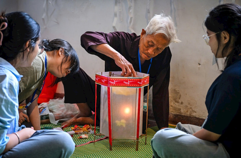 Nghệ nhân Nguyễn Văn Quyền chia sẻ với các bạn nhỏ nhiều ứng dụng khoa học trong cách làm đèn kéo quân truyền thống. z7063698543825-eed9c1bd8b961ccbbbd4f238b5196f8a.jpg