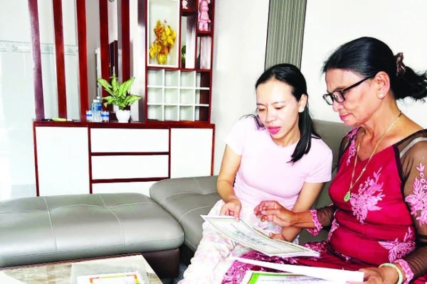 Bà Dư Thị Ánh (68 tuổi) bên những tấm bằng khen, giấy chứng nhận thành tích học tập của con cháu được gìn giữ cẩn thận.