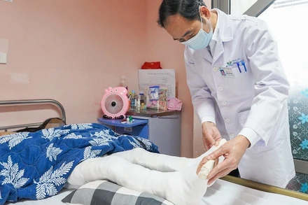 Tiến sĩ, bác sĩ Hoàng Hải Đức, Trưởng khoa Chỉnh hình thăm khám cho bệnh nhi sau phẫu thuật.