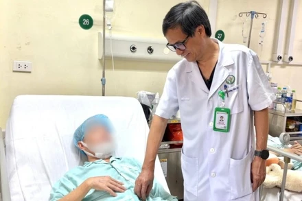 Phó Giáo sư, Tiến sĩ Đồng Văn Hệ thăm khám người bệnh sau phẫu thuật.