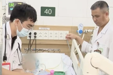 Tiến sĩ, bác sĩ Nguyễn Trung Nguyên, Giám đốc Trung tâm Chống độc (bên phải) và đồng nghiệp kiểm tra phản xạ cơ cho bệnh nhân.