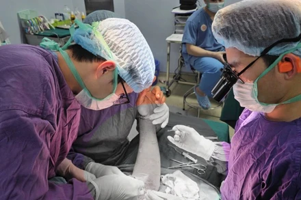 Bác sĩ tiến hành phẫu thuật trồng lại cánh tay đứt rời cho người bệnh. 