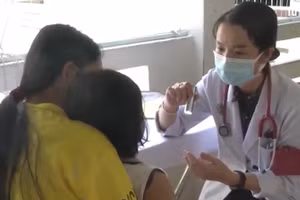 Bác sĩ khám cho bệnh nhi mắc tay chân miệng.