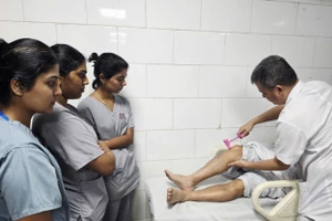 Tiến sĩ, bác sĩ Nguyễn Trung Nguyên - Giám đốc Trung tâm Chống độc, Bệnh viện Bạch Mai kiểm tra phản xạ của các bệnh nhân ngộ độc cá chình.