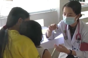 Bác sĩ khám cho bệnh nhi mắc tay chân miệng.