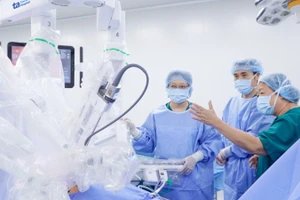 Bác sĩ chuyên khoa II Nguyễn Bá Mỹ Nhi (phải) hướng dẫn ê-kíp bác sĩ trước khi phẫu thuật bằng robot Da Vinci Xi.