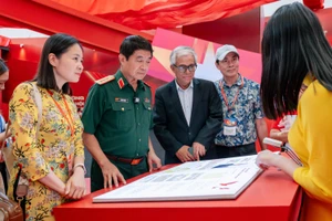 Đại sứ Phạm Quang Vinh và Thượng tướng Võ Văn Tuấn đang trải nghiệm sách tương tác về các kỳ Đại hội Đảng - nơi lưu giữ và giới thiệu các quyết sách trọng đại của Đảng Cộng sản Việt Nam.