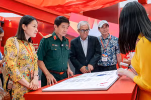 Đại sứ Phạm Quang Vinh và Thượng tướng Võ Văn Tuấn đang trải nghiệm sách tương tác về các kỳ Đại hội Đảng - nơi lưu giữ và giới thiệu các quyết sách trọng đại của Đảng Cộng sản Việt Nam.