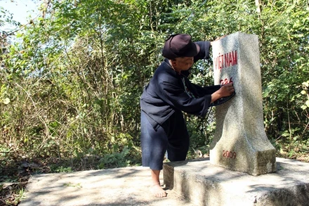 Già Xiết cẩn thận lau chùi cột mốc