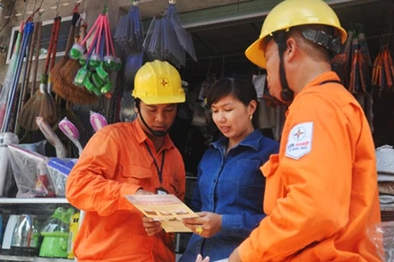 Công nhân ngành điện Thủ đô tuyên truyền, vận động người dân sử dụng điện an toàn, hiệu quả, phòng chống cháy nổ. Ảnh: TOÀN THẮNG