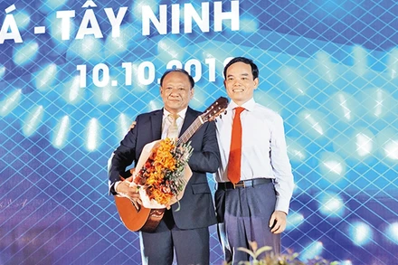 Bí thư Tỉnh ủy Trần Lưu Quang (bên phải) tặng đàn ghi-ta cho một nhà đầu tư.