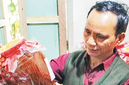 Già làng Lê Văn Nghĩa bên sản phẩm tâm huyết. Ảnh: TRẦN LÊ LÂM