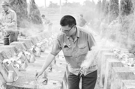 Cựu chiến binh Nguyễn Đình Thắng thắp hương cho đồng đội cũ ở Nghĩa trang Vị Xuyên.