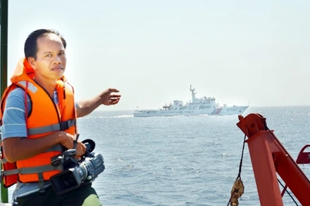 Thiếu tá Lê Văn Chương đang tác nghiệp trên vùng biển Tri Tôn (Hoàng Sa) tháng 5-2014. Ảnh: VĂN LÊ