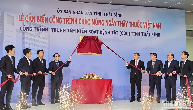Các đại biểu thực hiện nghi thức gắn biển công trình chào mừng Ngày Thầy thuốc Việt Nam cho tòa nhà CDC Thái Bình.