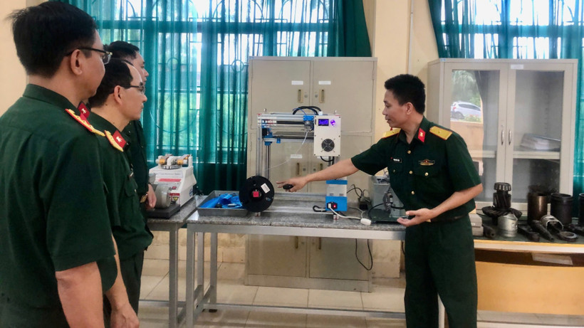 Cán bộ Trường Cao đẳng Kỹ thuật Quân sự 1 giới thiệu mô hình máy in 3D, một sản phẩm ứng dụng công nghệ số trong nghiên cứu khoa học tại đơn vị.