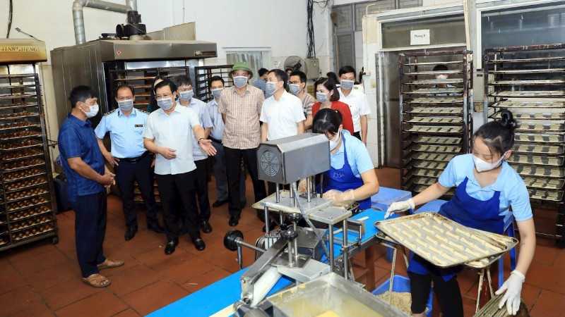 Đoàn khảo sát của Thường trực HĐND thành phố Hà Nội kiểm tra việc chấp hành các quy định của pháp luật về an toàn thực phẩm tại một cơ sở sản xuất bánh kẹo ở xã An Khánh. (Ảnh: LÊ HẢI)