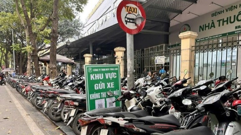 Điểm trông giữ xe máy trên hè phố Phủ Doãn, khiến người đi bộ buộc phải đi xuống lòng đường, rất nguy hiểm.