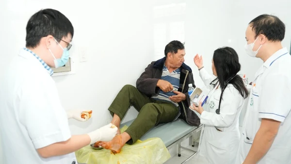 Các bác sĩ trong đoàn công tác trực tiếp xử trí một ca cấp cứu chấn thương bàn chân cho người.